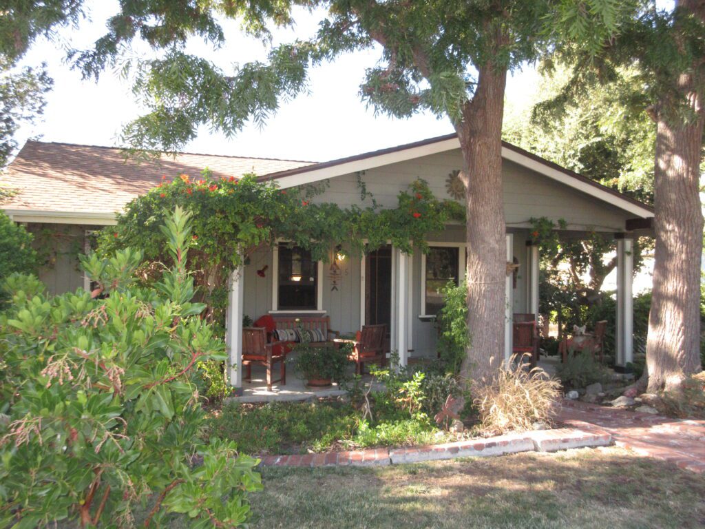 A visual of a small house hidden by trees